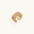 Two-tone ring with geometric lattice pattern in gold and silver finish with crystal accents on beige background