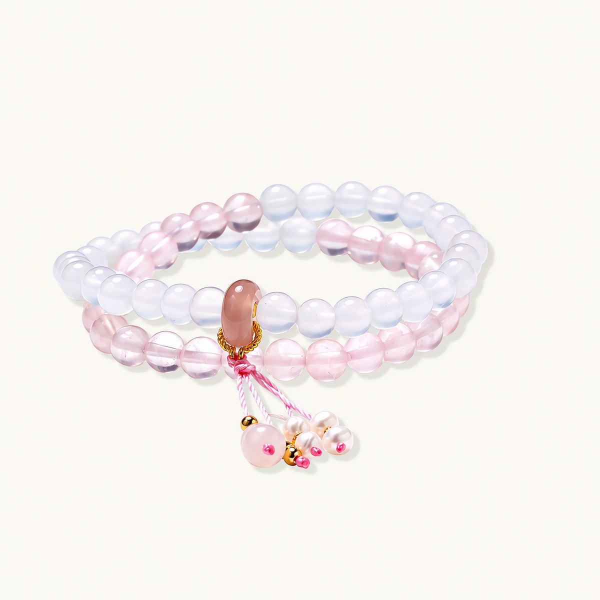 Double-wrap lavender beaded bracelet with rose quartz, pearls, gold vermeil charm and pink tassel on white background.