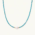 Dainty teal apatite beaded necklace with a single freshwater pearl centerpiece flanked by two small gold beads, adjustable gold clasp.
