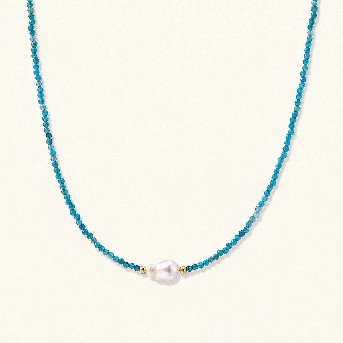 Dainty teal apatite beaded necklace with a single freshwater pearl centerpiece flanked by two small gold beads, adjustable gold clasp.