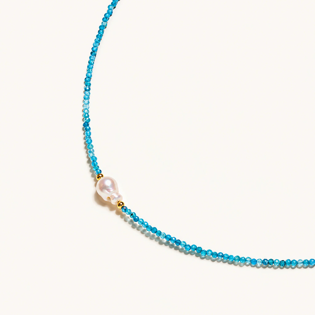 Dainty teal apatite beaded necklace with a single freshwater pearl centerpiece flanked by two small gold beads, adjustable gold clasp.