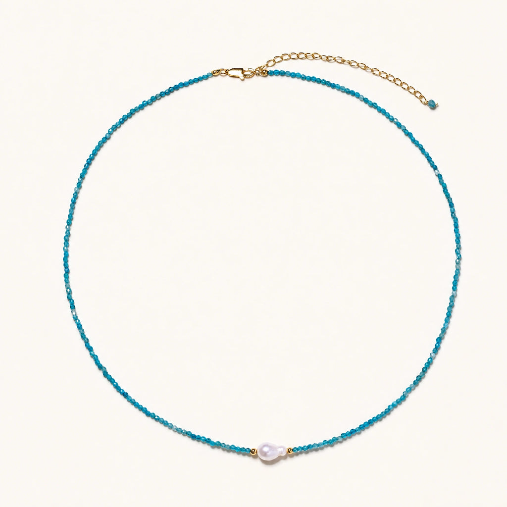 Dainty teal apatite beaded necklace with a single freshwater pearl centerpiece flanked by two small gold beads, adjustable gold clasp.