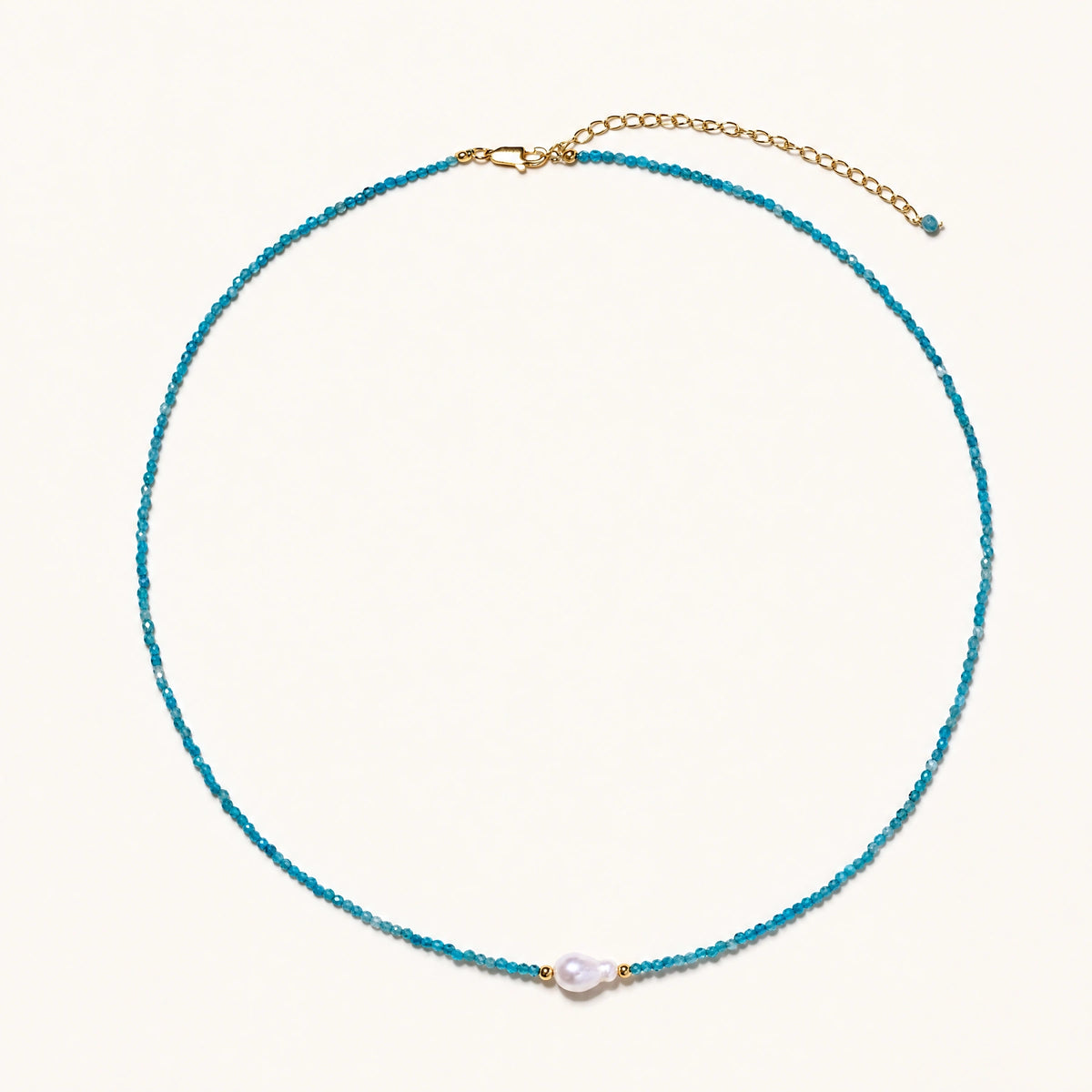 Dainty teal apatite beaded necklace with a single freshwater pearl centerpiece flanked by two small gold beads, adjustable gold clasp.