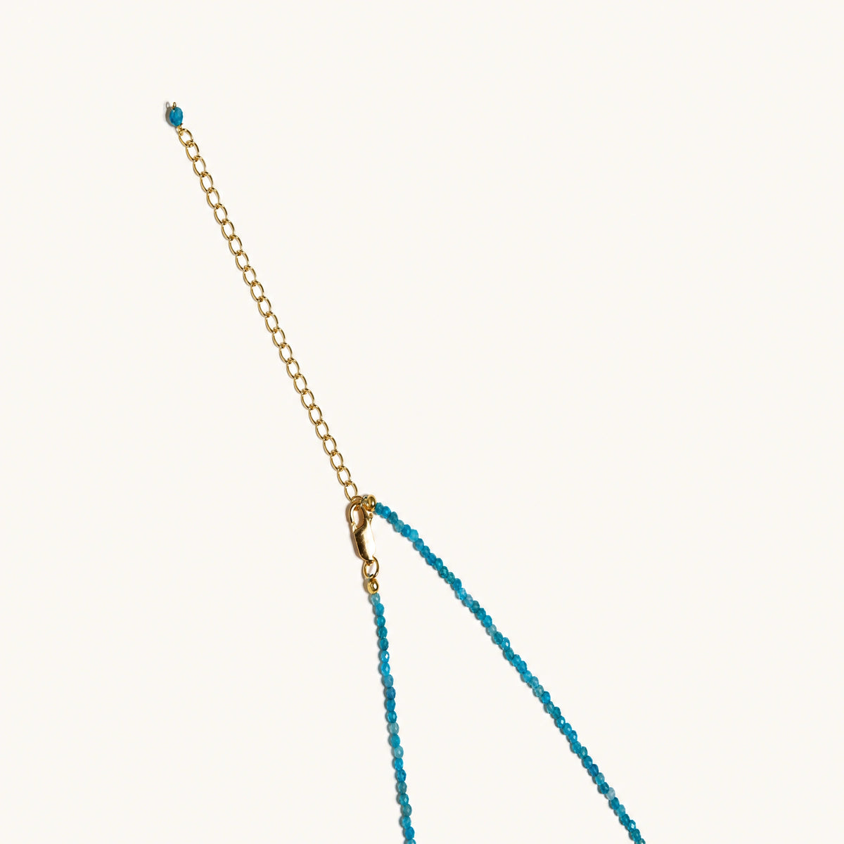 Dainty teal apatite beaded necklace with a single freshwater pearl centerpiece flanked by two small gold beads, adjustable gold clasp.