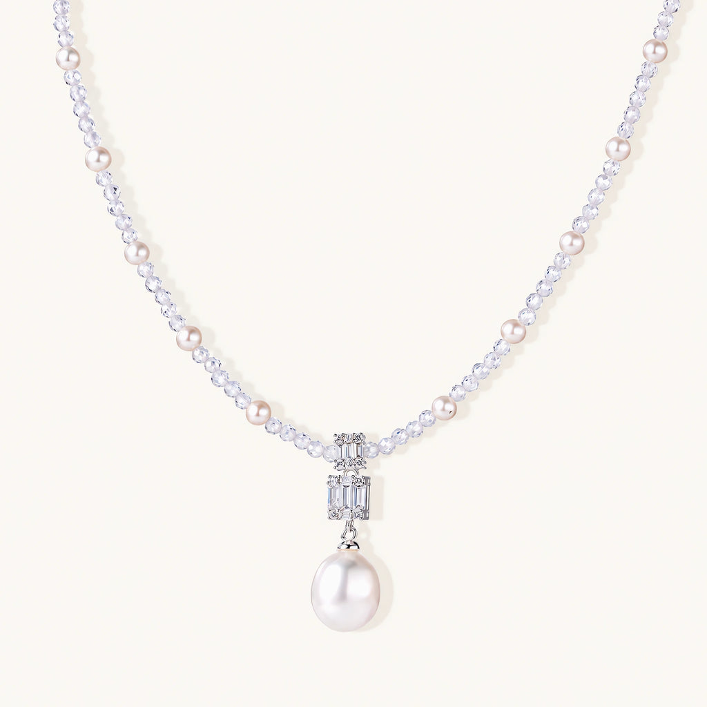 Dainty necklace with lavender crystal beads, freshwater pearls, geometric pendant, and large pearl drop on white background.