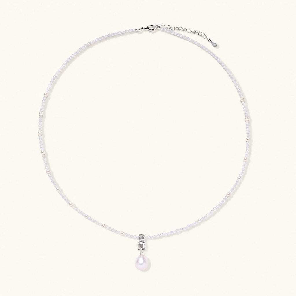 Dainty necklace with lavender crystal beads, freshwater pearls, geometric pendant, and large pearl drop on white background.