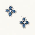 Pair of silver-tone four-petal flower stud earrings with blue denim fabric petals, a center white bead and zirconia accents.