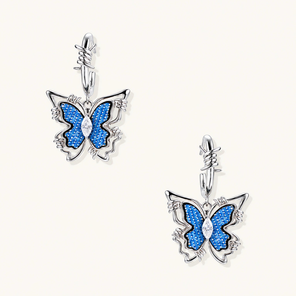 Silver hoop earrings with blue denim butterfly charms outlined in barbed wire design and central zirconia stone