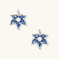 Pair of maple leaf stud earrings with blue denim fabric, a white bead center and zirconia accents in white gold plated eco-brass.
