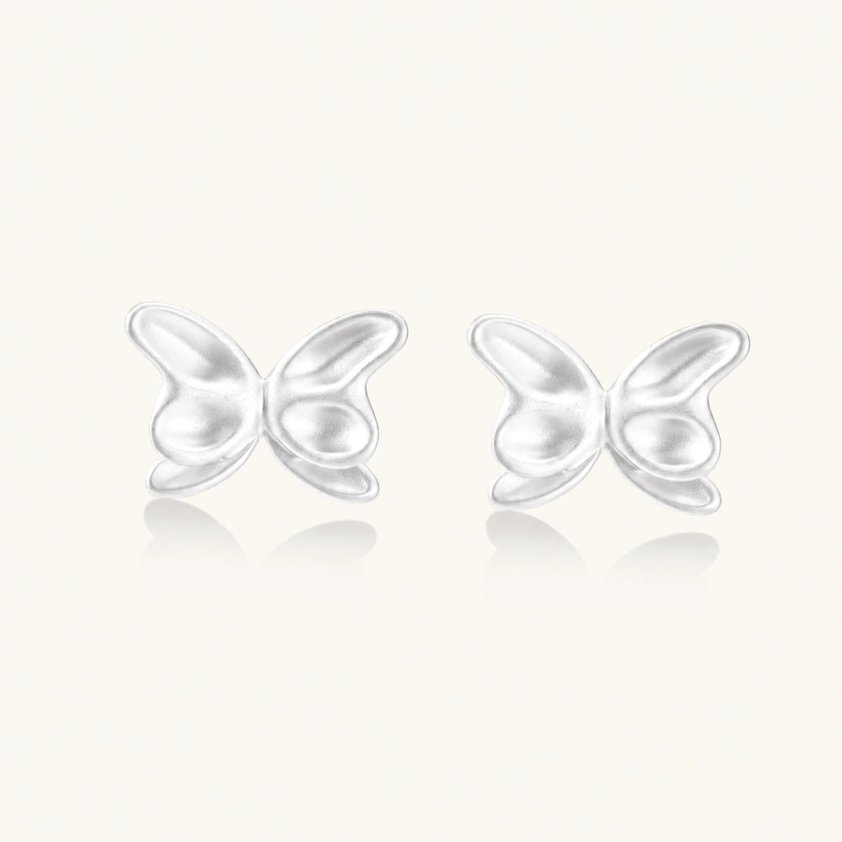 Pair of translucent butterfly-shaped stud earrings with frosted finish and dimensional wing details on white background