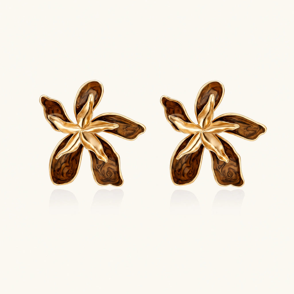 Gold-plated brass flower earrings with brown tortoiseshell enamel petals on cream background