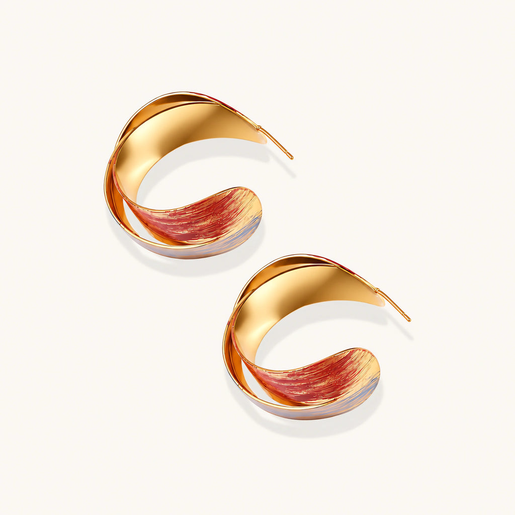 Sculptural gold-plated hoop earrings with diagonal purple and coral enamel stripes in twisted ribbon design