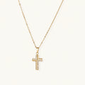 Gold-plated stainless steel cross necklace with crystal embellishments on adjustable chain against light background.