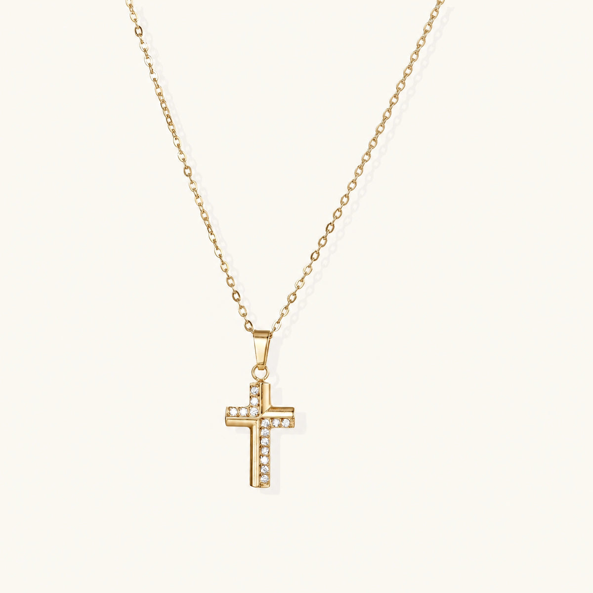 Gold-plated stainless steel cross necklace with crystal embellishments on adjustable chain against light background.