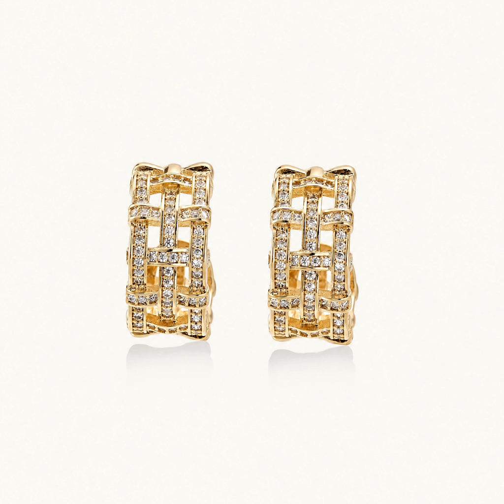 Gold-plated geometric hoop earrings with basket-weave lattice design and pavé crystal accents on cream background