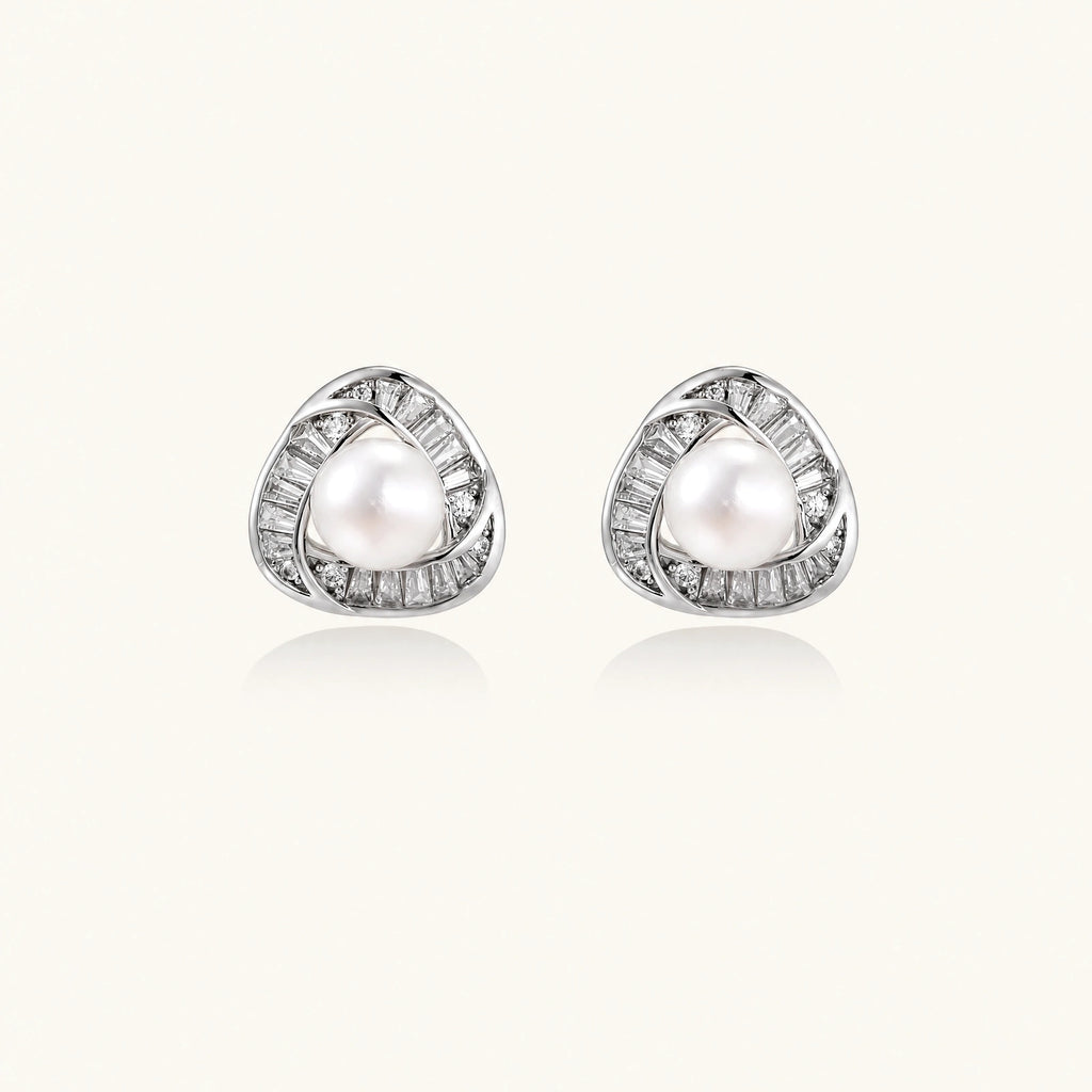 Triangular white gold plated stud earrings with central freshwater pearl and baguette-cut stones on white background