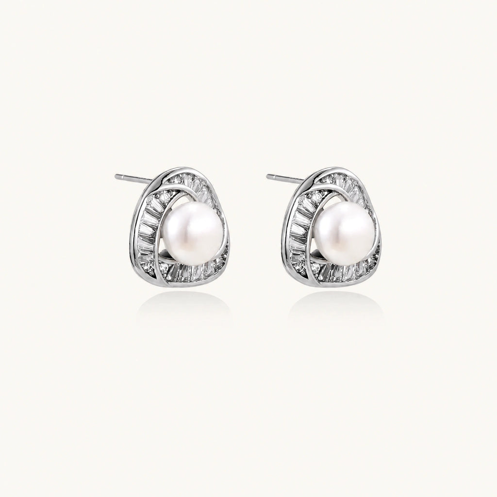 Triangular white gold plated stud earrings with central freshwater pearl and baguette-cut stones on white background