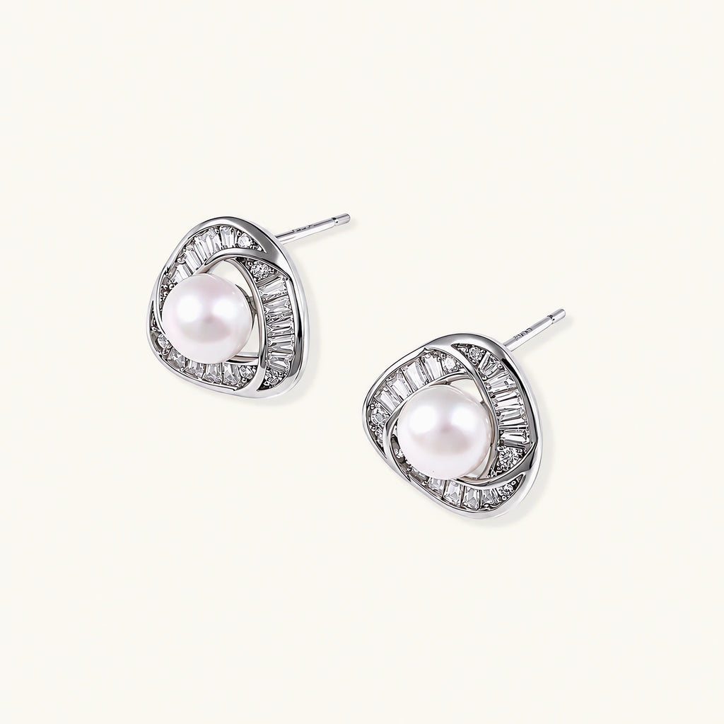 Triangular white gold plated stud earrings with central freshwater pearl and baguette-cut stones on white background
