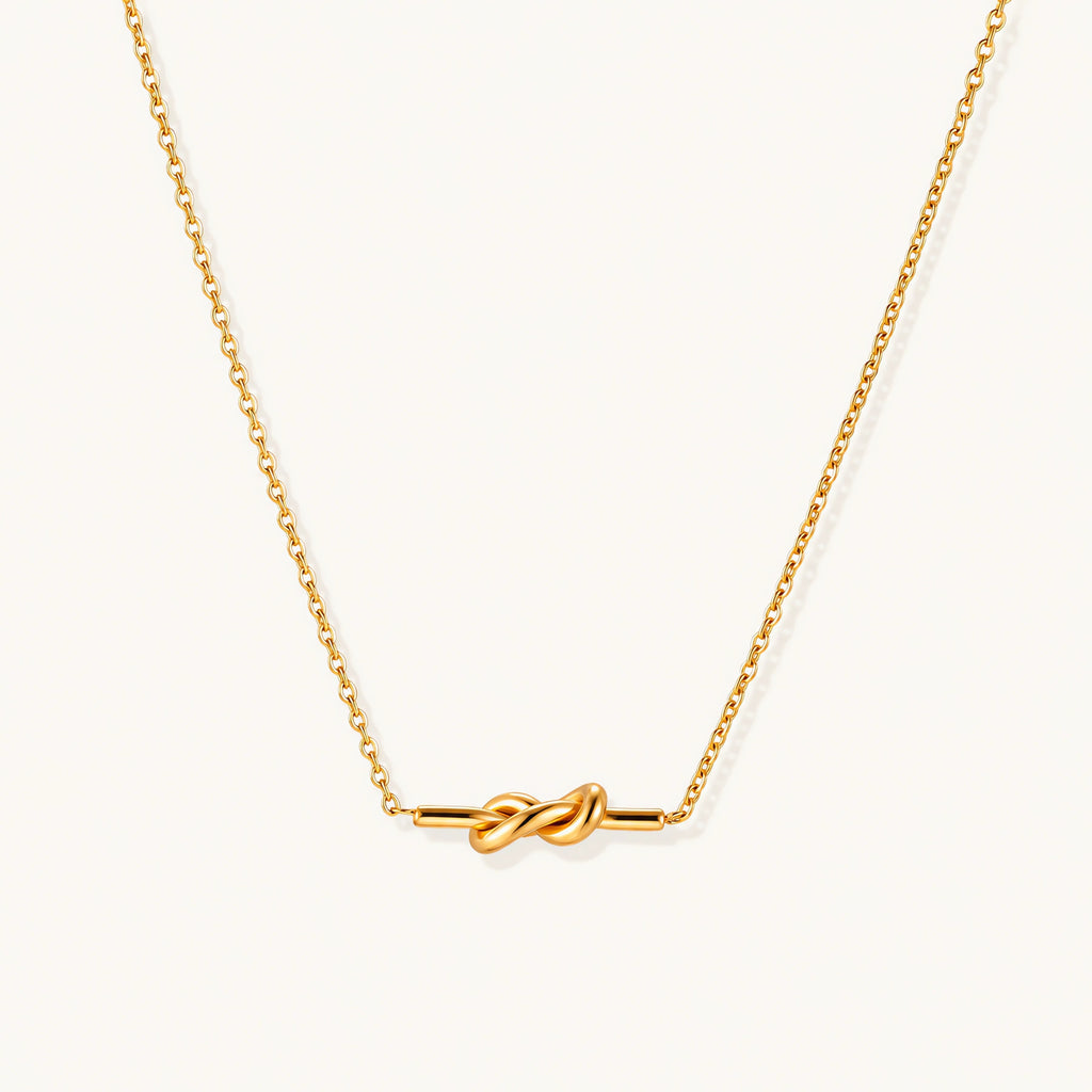 Dainty 18K gold plated necklace with infinity knot pendant on delicate chain against white background