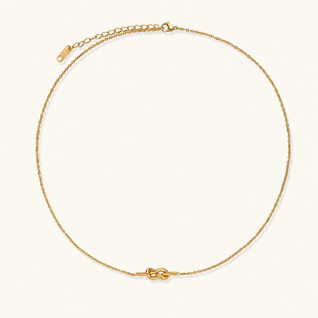 Dainty 18K gold plated necklace with infinity knot pendant on delicate chain against white background