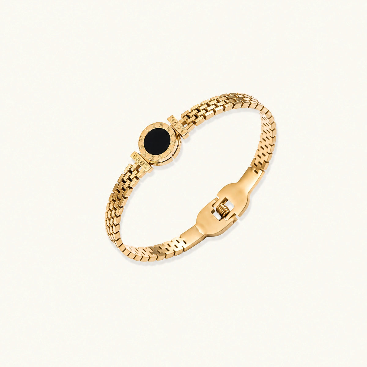 Gold mesh bracelet with circular black mother of pearl medallion featuring Roman numeral engravings and hinged clasp