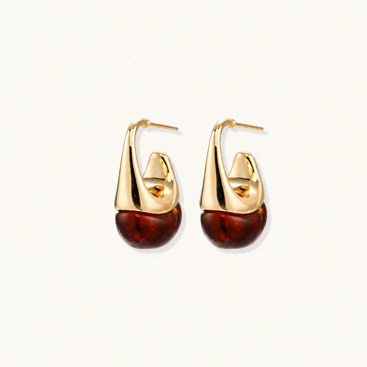 Modern drop earrings with curved gold-plated copper tops and amber resin bottoms creating an organic teardrop silhouette.
