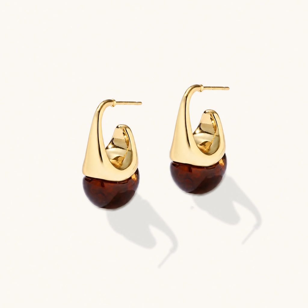 Modern drop earrings with curved gold-plated copper tops and amber resin bottoms creating an organic teardrop silhouette.