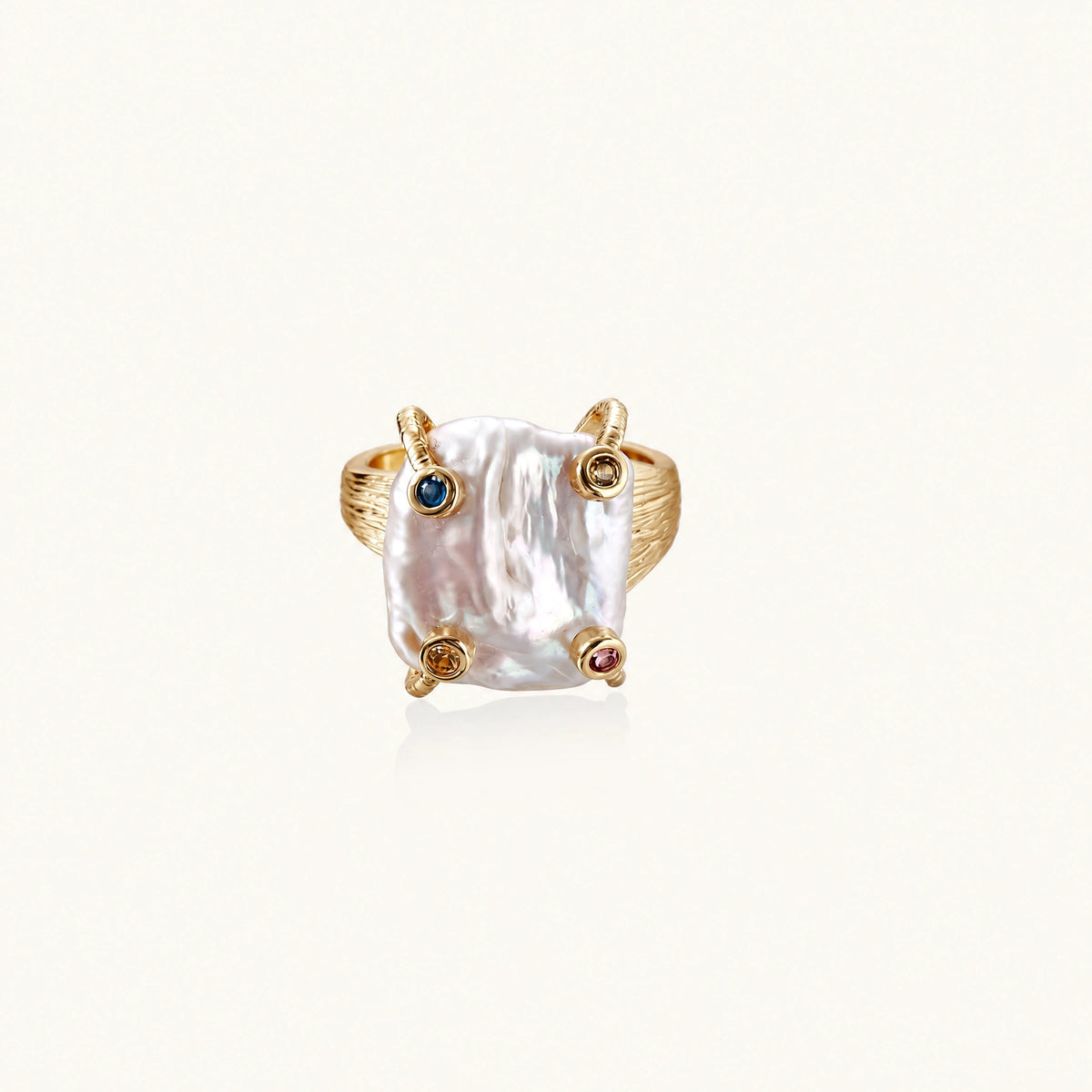 Gold ring with large iridescent baroque pearl and four colored gemstones on textured band