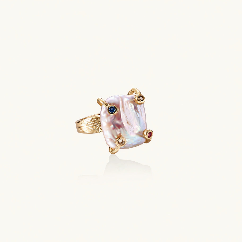 Gold ring with large iridescent baroque pearl and four colored gemstones on textured band