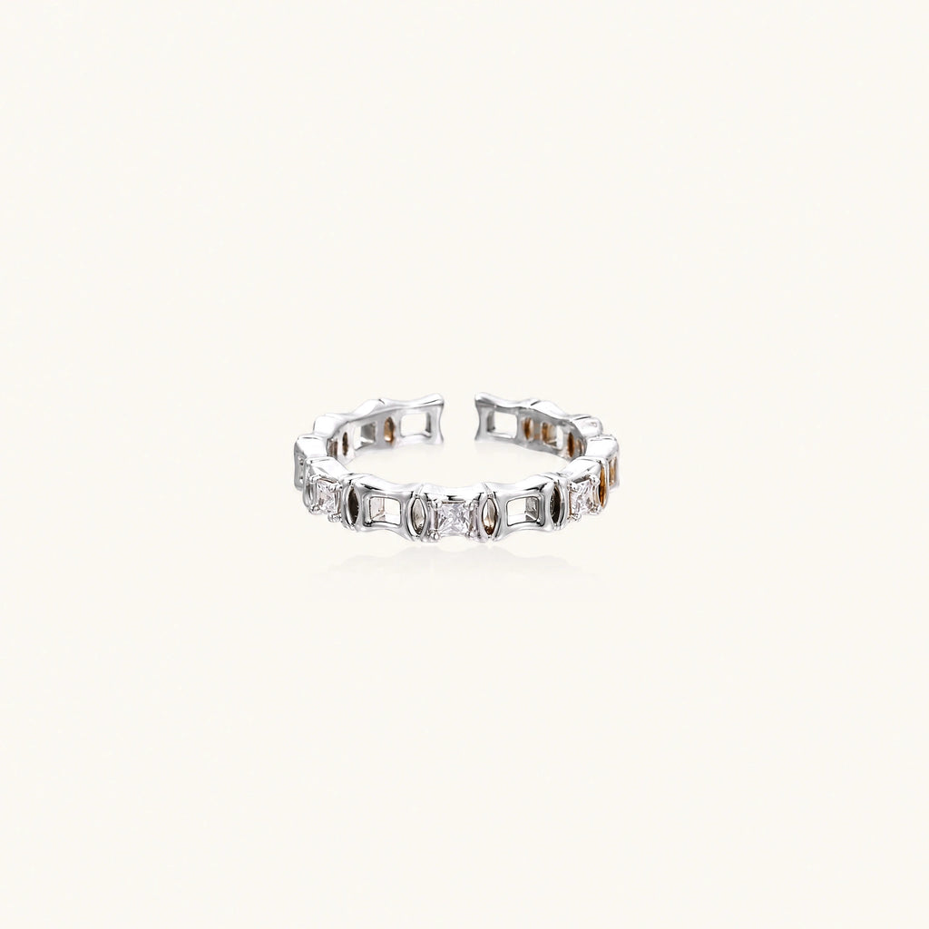 White gold plated ring with architectural lattice design and zirconia accents on cream background