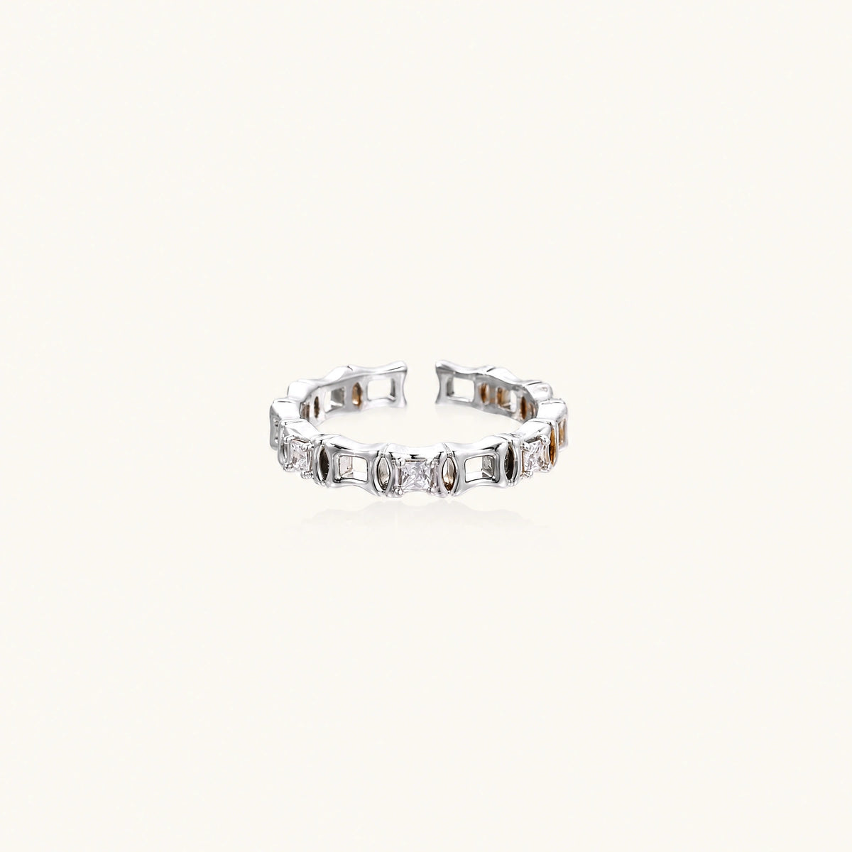 White gold plated ring with architectural lattice design and zirconia accents on cream background