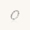 White gold plated ring with architectural lattice design and zirconia accents on cream background